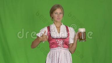 女孩把一杯啤酒放在一个孤立的绿色背景上。 巴伐利亚啤酒节庆祝活动。
